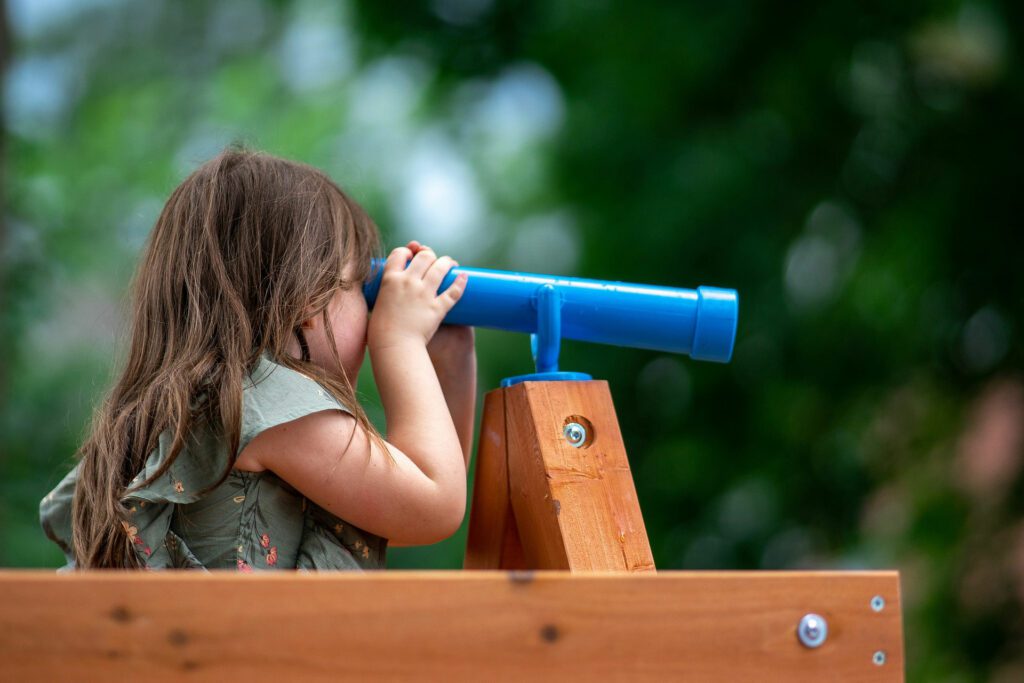 Little girl looking through a toy telescope