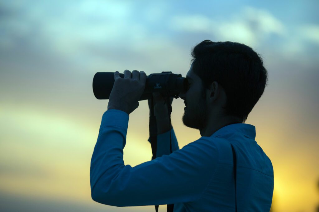 Man looking through binoculars-Good binoculars or a cheap telescope?